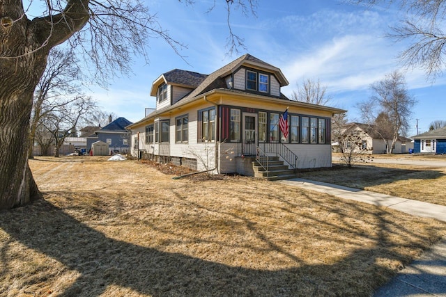 bungalow-style home with entry steps and a front lawn