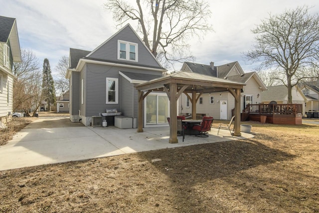 rear view of property featuring a gazebo and a patio