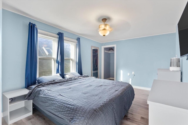 bedroom featuring ceiling fan, baseboards, and wood finished floors