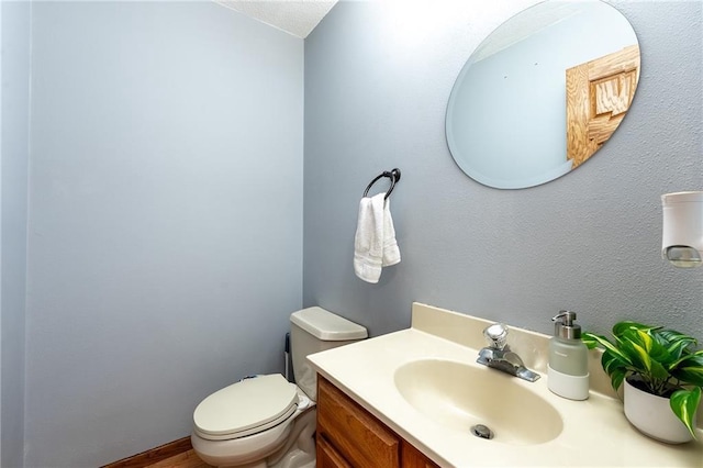 half bath featuring toilet and vanity