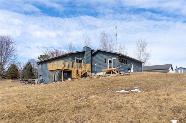 back of house with a deck, a lawn, and a chimney