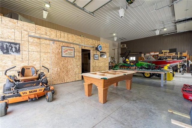 rec room featuring metal wall, concrete floors, and a garage