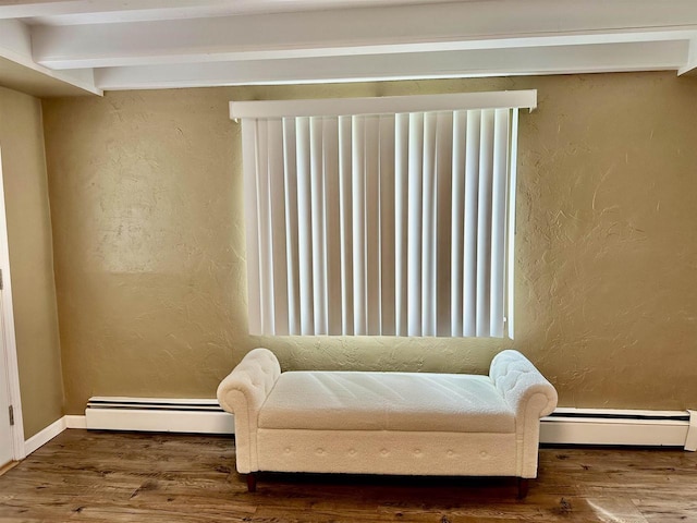 living area featuring a baseboard radiator, a baseboard heating unit, wood finished floors, and a textured wall