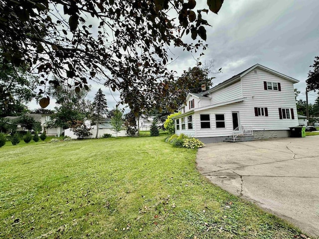 view of side of property with a yard and a chimney