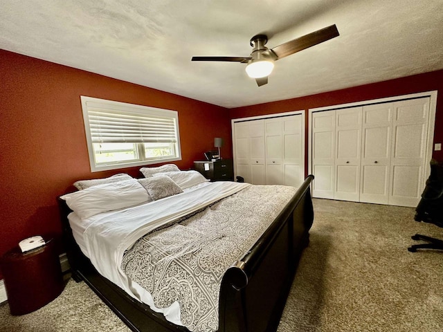 carpeted bedroom with a ceiling fan and multiple closets