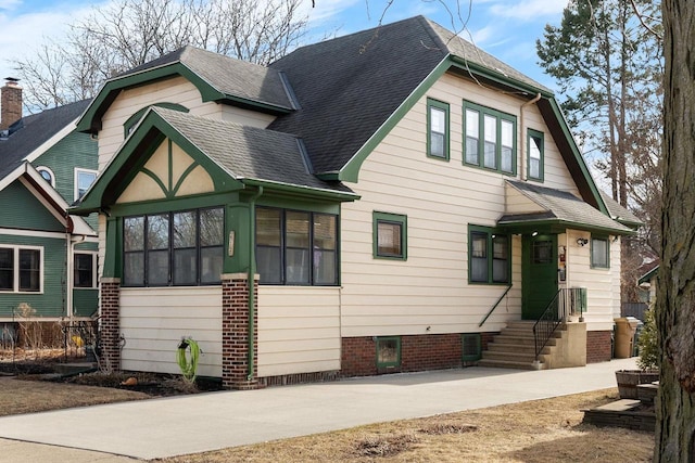 view of front of property with a sunroom and a shingled roof