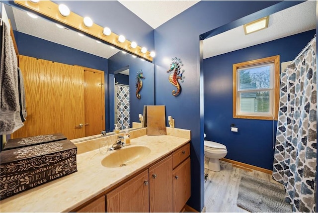 bathroom featuring toilet, curtained shower, wood finished floors, baseboards, and vanity