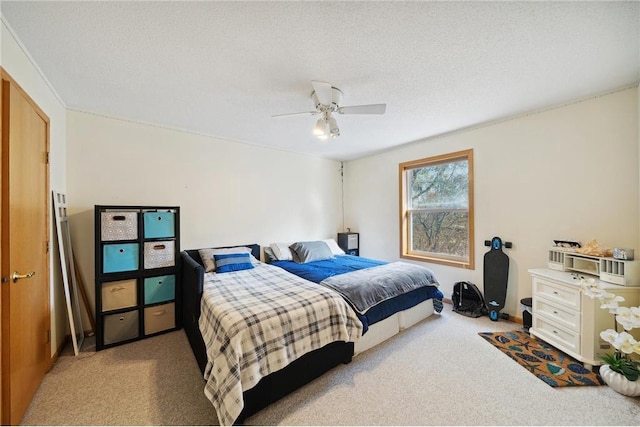 bedroom with ceiling fan, carpet flooring, and a textured ceiling