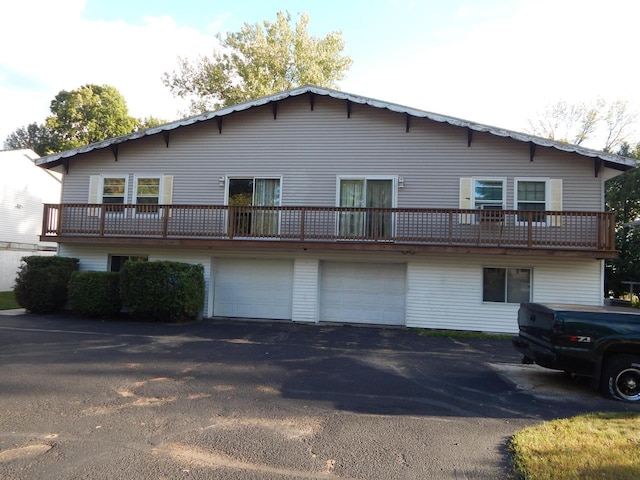 back of house with driveway and a garage