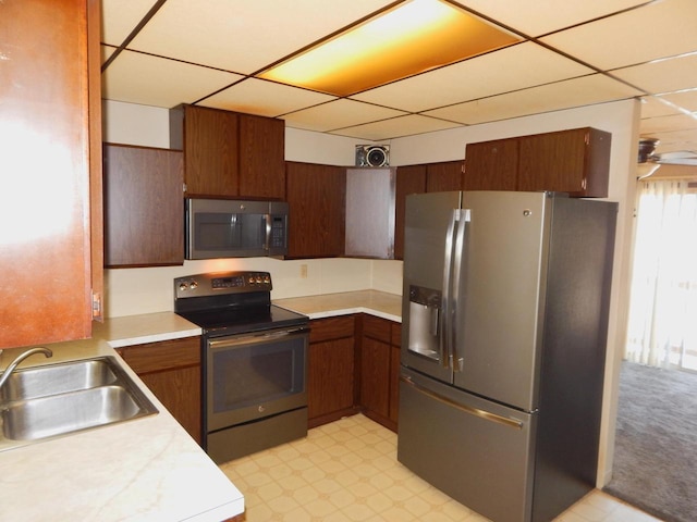 kitchen with a sink, stainless steel appliances, light floors, and light countertops