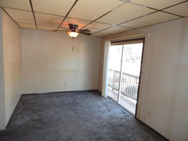 carpeted spare room featuring visible vents, a paneled ceiling, baseboards, and ceiling fan