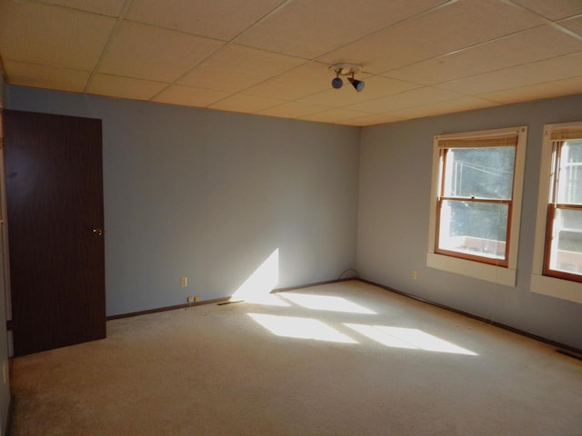 carpeted empty room featuring baseboards