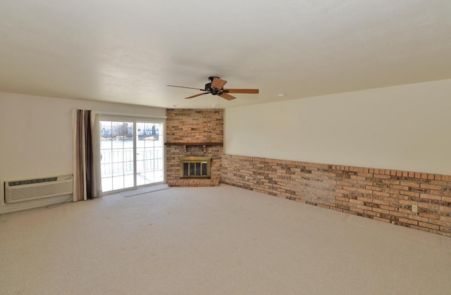 unfurnished living room featuring a ceiling fan, carpet, brick wall, a wall mounted AC, and a brick fireplace