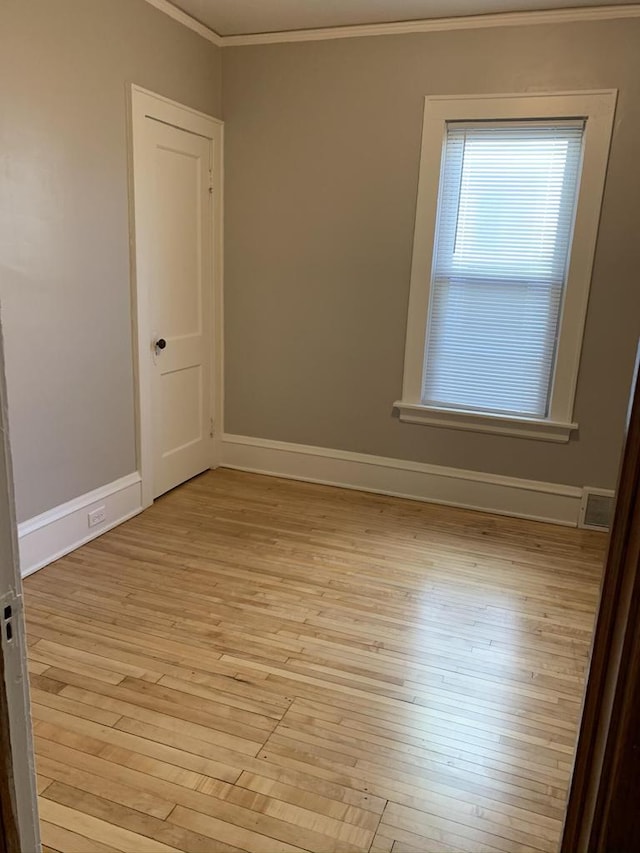 unfurnished room featuring visible vents, baseboards, ornamental molding, and light wood finished floors