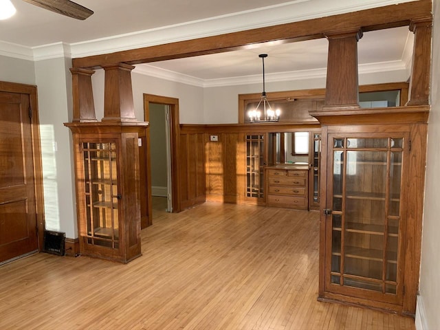 interior space featuring decorative light fixtures, a chandelier, hardwood / wood-style floors, and crown molding