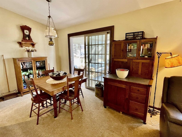 dining area with light colored carpet and vaulted ceiling