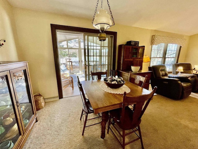 carpeted dining space featuring baseboards and a baseboard radiator