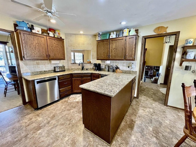 kitchen with a sink, tasteful backsplash, stainless steel dishwasher, and a peninsula