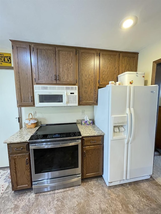 kitchen featuring white appliances and light stone countertops