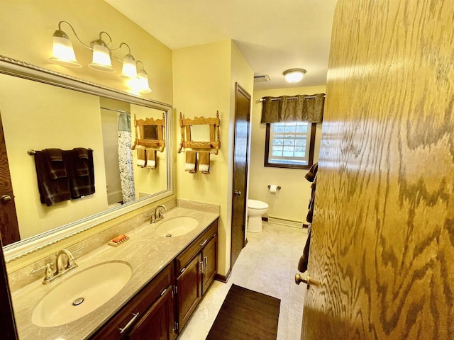 bathroom with a sink, visible vents, toilet, and double vanity