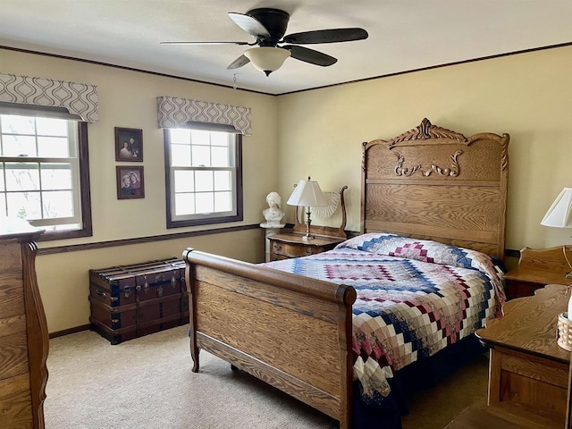 bedroom featuring baseboards, carpet floors, ornamental molding, and a ceiling fan