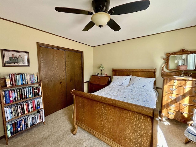 bedroom featuring a closet, light carpet, ornamental molding, and a ceiling fan