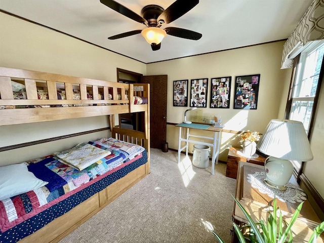 carpeted bedroom with ceiling fan and ornamental molding