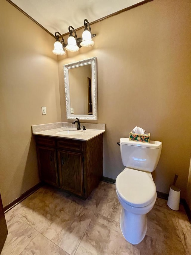 bathroom with baseboards, toilet, and vanity