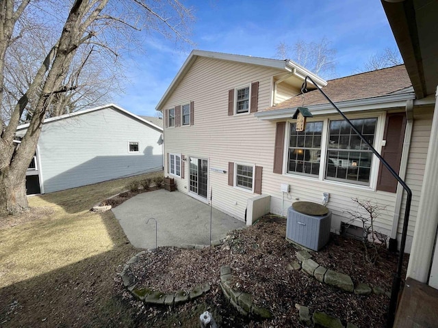 back of property featuring a patio, central AC, and roof with shingles