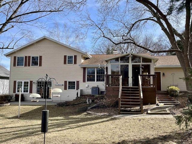 tri-level home with stairs, cooling unit, a sunroom, and a chimney