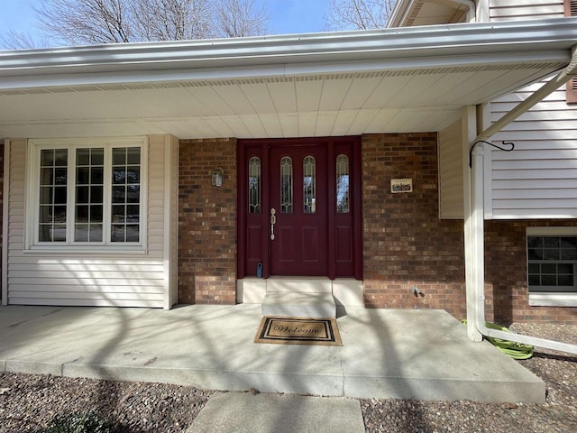 property entrance with brick siding and covered porch