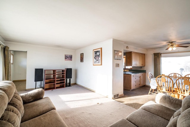 living area featuring visible vents, baseboards, light colored carpet, and ornamental molding