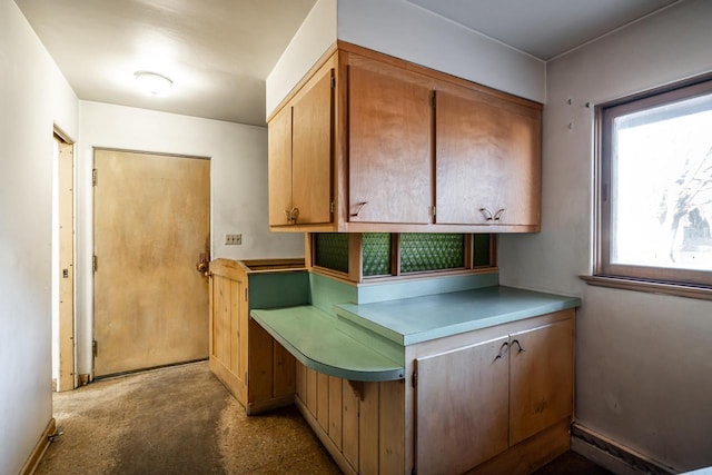 kitchen featuring light countertops, baseboards, and concrete flooring