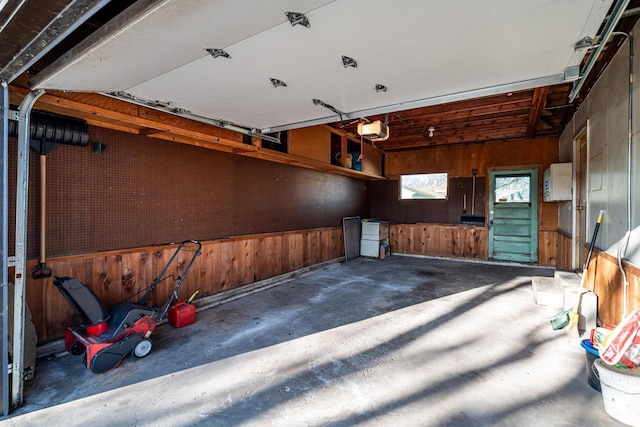 garage featuring a garage door opener and wood walls