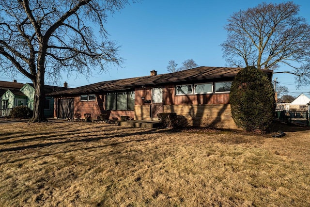 ranch-style house with a chimney, a front lawn, and fence