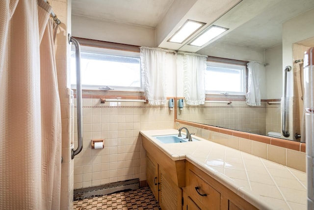 full bathroom featuring curtained shower, vanity, and tile walls