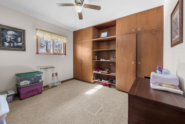 office space with ceiling fan, baseboards, and light carpet