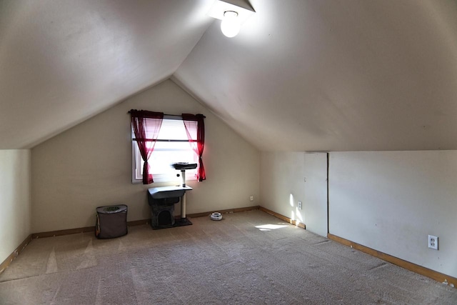 additional living space with baseboards, lofted ceiling, and carpet