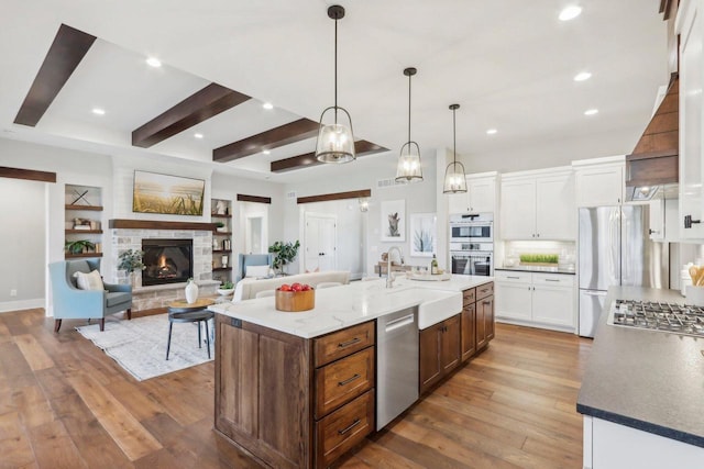 kitchen with white cabinetry, hardwood / wood-style flooring, appliances with stainless steel finishes, and a sink