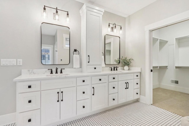 bathroom featuring double vanity, baseboards, visible vents, and a sink