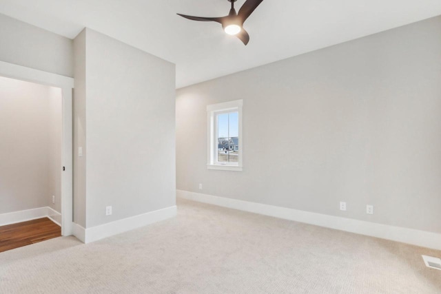 unfurnished room with light colored carpet, baseboards, and ceiling fan