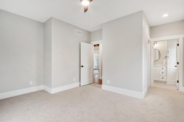 unfurnished bedroom with visible vents, baseboards, recessed lighting, light colored carpet, and connected bathroom