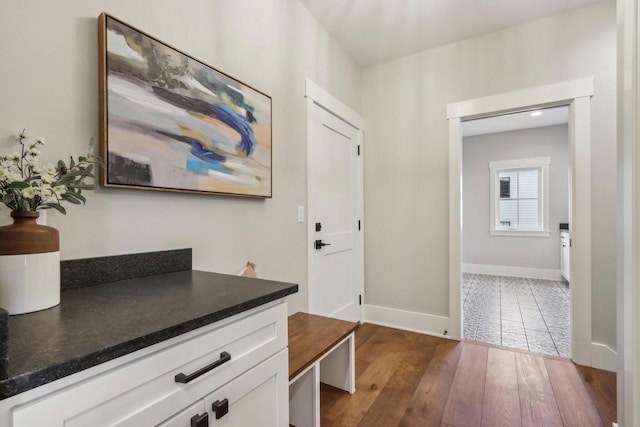 hall with baseboards and dark wood-style flooring