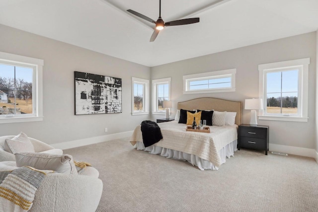 bedroom with multiple windows, baseboards, and light carpet