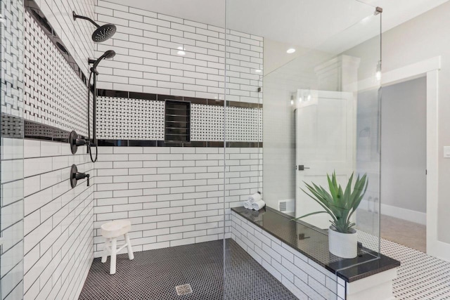 full bath featuring baseboards and tiled shower