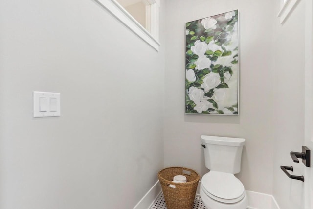 bathroom with toilet and baseboards