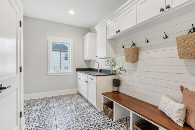 mudroom featuring light tile patterned floors, baseboards, and a sink