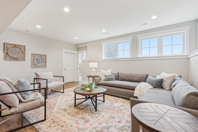 living room featuring recessed lighting, light wood-type flooring, baseboards, and visible vents