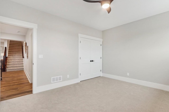 unfurnished bedroom with a ceiling fan, baseboards, visible vents, carpet floors, and a closet