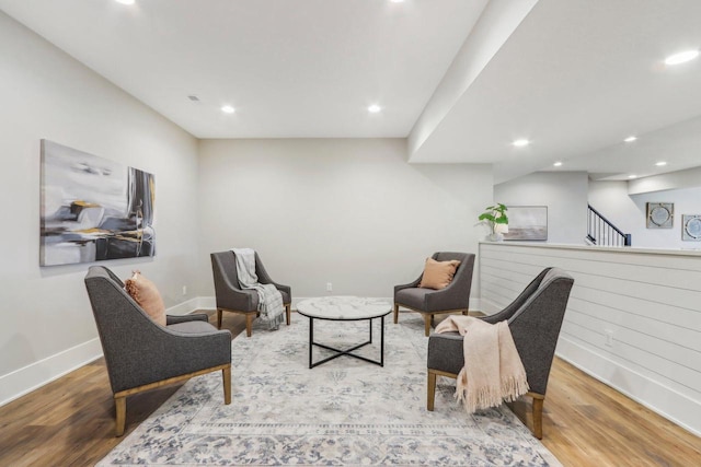 living area with stairs, recessed lighting, wood finished floors, and baseboards